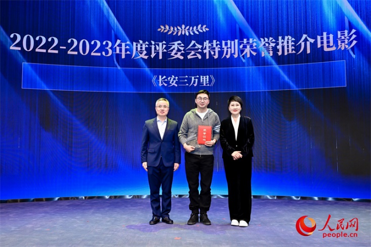 人民网总编辑赵强（左一）和表演艺术家张凯丽（右一）为于洲颁发“2022-2023年度评委会特别荣誉推介电影”