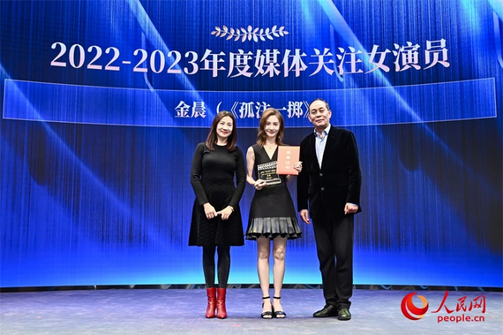 中国电影表演艺术学会秘书长张光北（右一）与演员陈炜（左一）为金晨颁发“2022-2023年度媒体关注女演员”