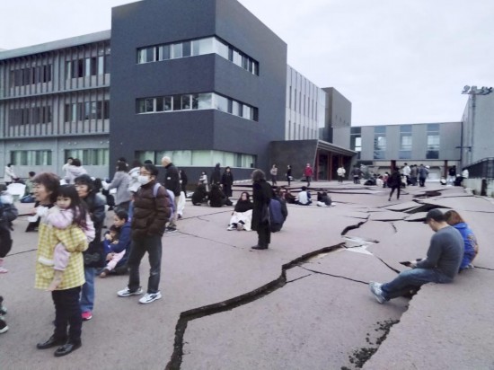  1月1日，在日本石川县轮岛市，人们站在被地震破坏的地面上。新华社/共同社