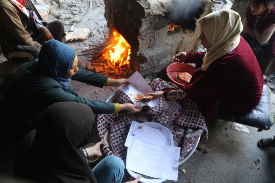  1月8日，人们在加沙地带北部杰巴利耶难民营生火做饭。新华社发（阿布德摄）