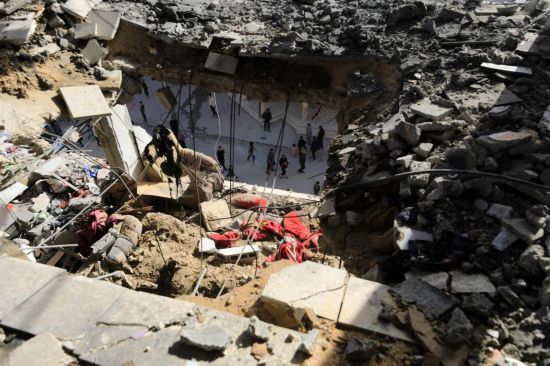  1月10日，在加沙地带南部城市拉法，巴勒斯坦人查看被以军空袭后的住宅。新华社发（亚西尔·库迪摄）