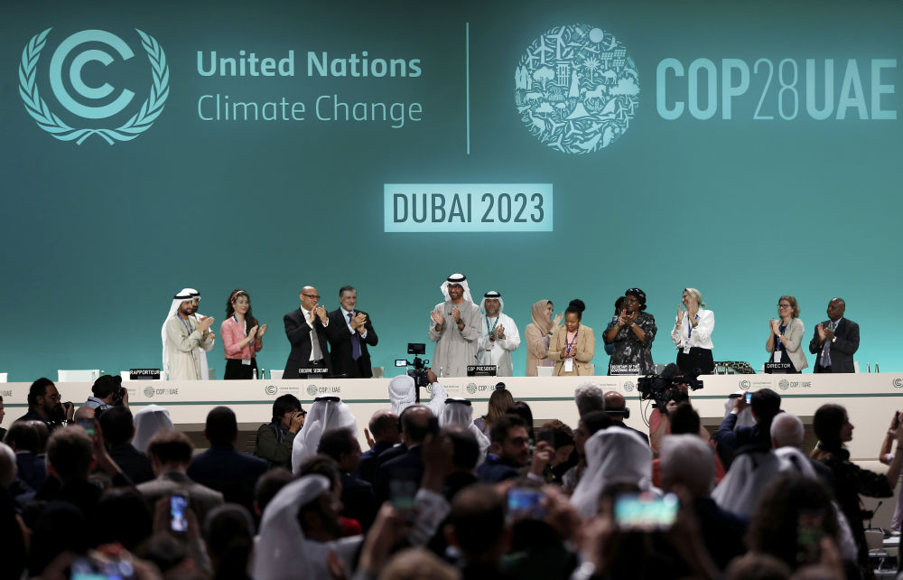 2023年12月13日，在阿联酋迪拜举行的《联合国气候变化框架公约》第二十八次缔约方大会在“加时”一天后闭幕。这是大会主席苏尔坦·贾比尔宣布达成“阿联酋共识”后，参会人员起立鼓掌。新华社记者 王东震 摄