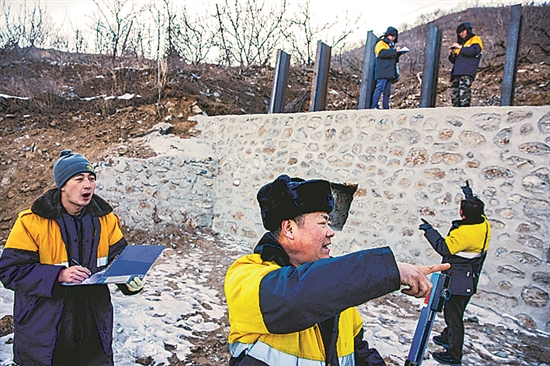 1月15日，门头沟区妙峰山镇，来自中国铁路北京局的单秀松（左二）与同事正在铁路线上进行防洪隐患排查工作。