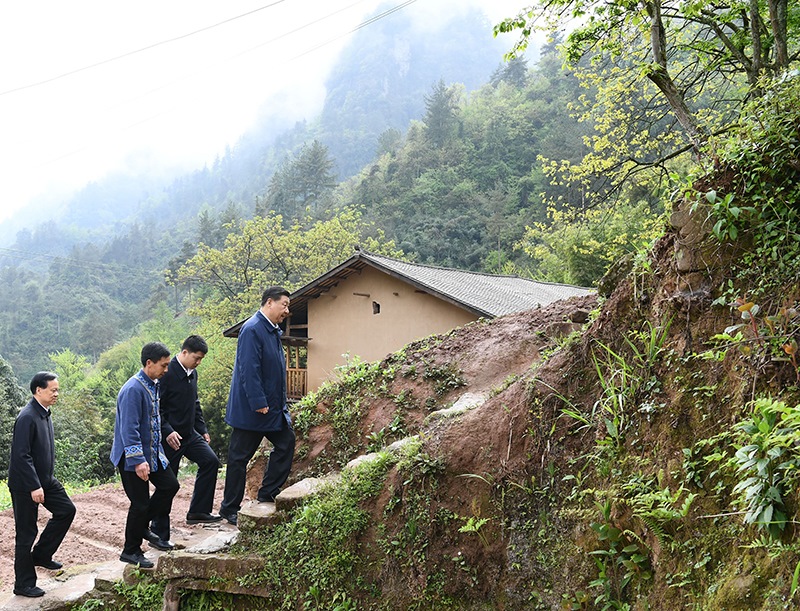 2019年4月15日，在重庆石柱土家族自治县中益乡华溪村，习近平总书记踏着湿滑的石阶登上陡坡，前往贫困户谭登周家看望。