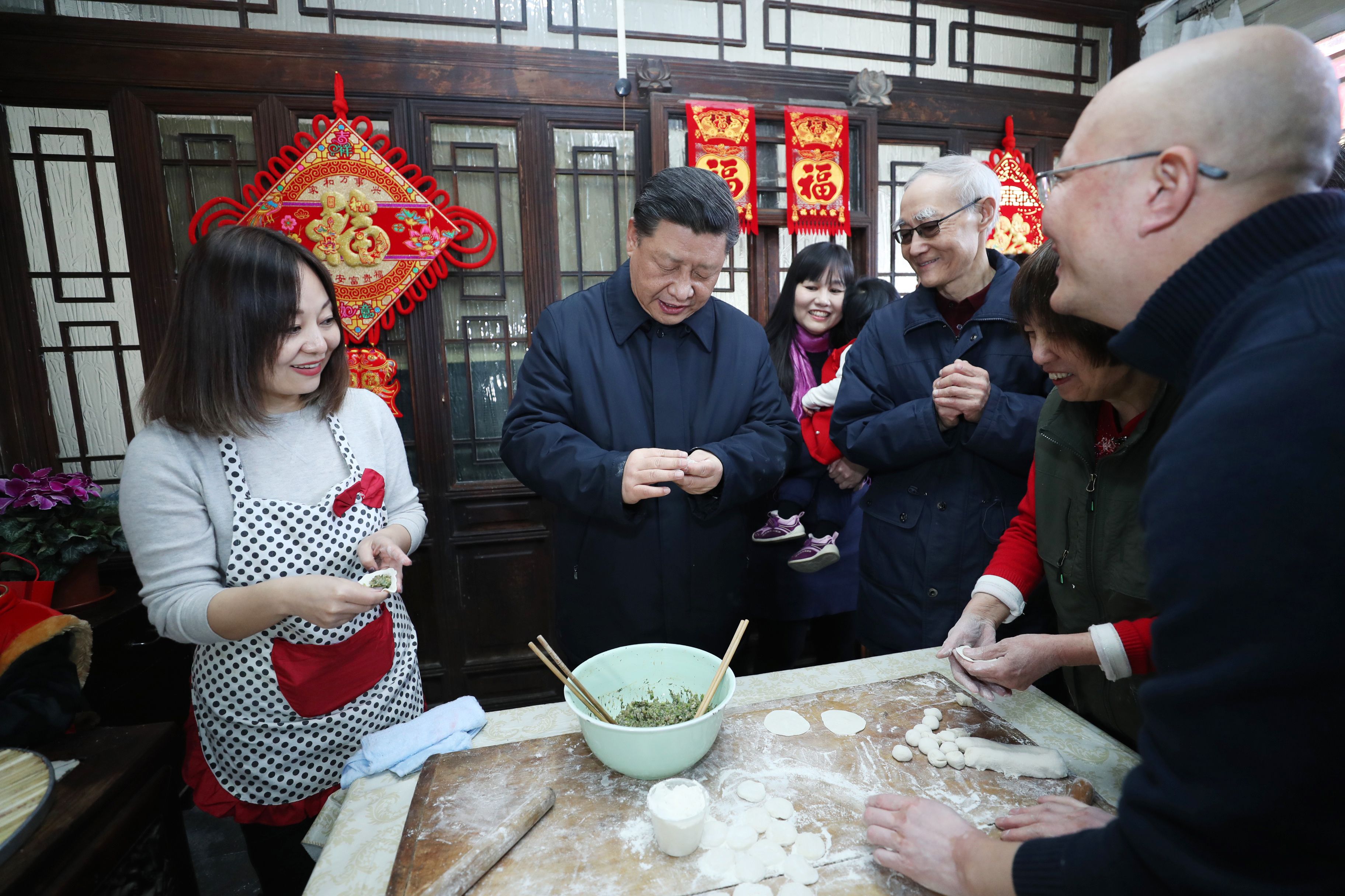 △ 2019年2月1日，习近平总书记在北京前门东区草厂四条胡同，同朱茂锦一家人包饺子、聊家常。