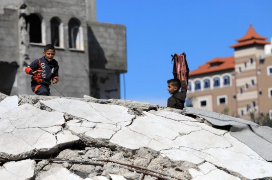 2月17日，在加沙地带南部城市拉法，巴勒斯坦儿童在废墟上放风筝。新华社发（亚西尔·库迪摄）