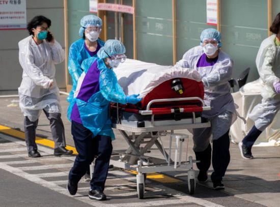 2020年3月4日，在韩国大邱庆北大学医院，医护人员转送患者。新华社发（李相浩摄）