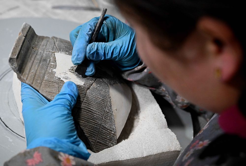 在中国社会科学院考古研究所安阳工作站，工作人员在对殷墟洹北商城出土的陶片进行整理修复（2月23日摄）。