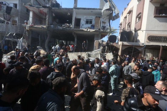 2月24日，在加沙地带南部城市拉法，人们聚集在遭以军空袭的建筑前。新华社发（哈立德·奥马尔摄）