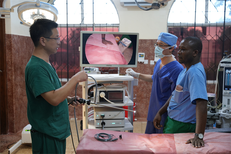 医疗队队长蒋国庆指导当地外科医生调试腹腔镜设备。中国援桑医疗队供图