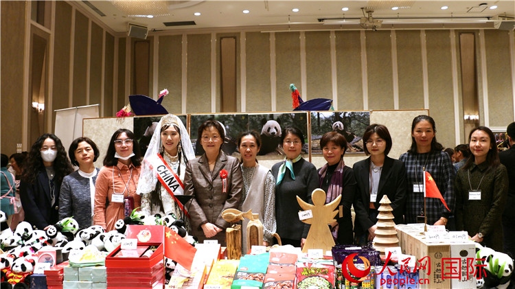 中国驻日本大使吴江浩夫人丁玥（左五）与使馆人员在展位前合影留念。人民网 许可摄