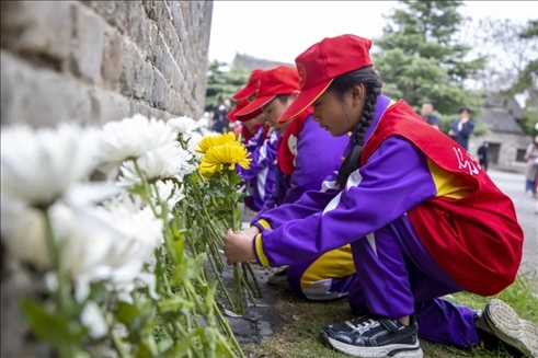 在山东枣庄台儿庄古城，当地学生参加鲜花祭奠活动。（受访单位供图）