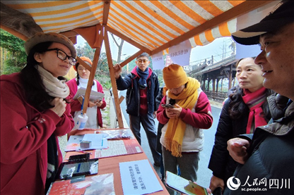 1月6日，“2024成都蒲江柑甜采摘节”上，记者见到了小萌（左一）和许多年轻人忙着做访客接待、现场布置、票务核对、采摘服务等工作。人民网记者朱虹摄