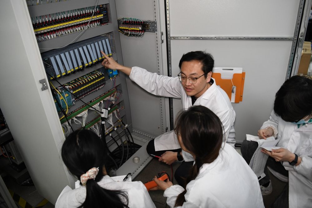 2024年4月6日，在位于安徽合肥的中国科学技术大学，安徽省先进功能高分子薄膜工程实验室团队成员在检修自主研制的高分子薄膜原位双向拉伸实验设备的电气控制系统。