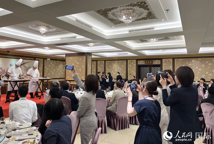 国家级非物质文化遗产、全聚德片鸭工艺吸引代表团成员拍照留念。