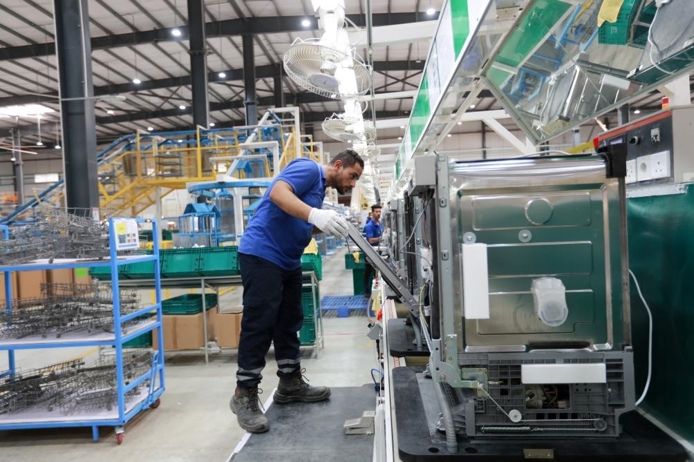 2023年8月10日,埃及苏伊士省中埃·泰达苏伊士经贸合作区,当地员工在中企洗碗机生产线上工作。