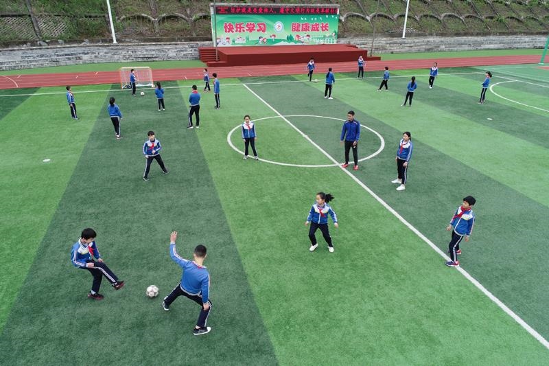 陕西安康平利县老县镇中心小学的学生在操场上踢球。