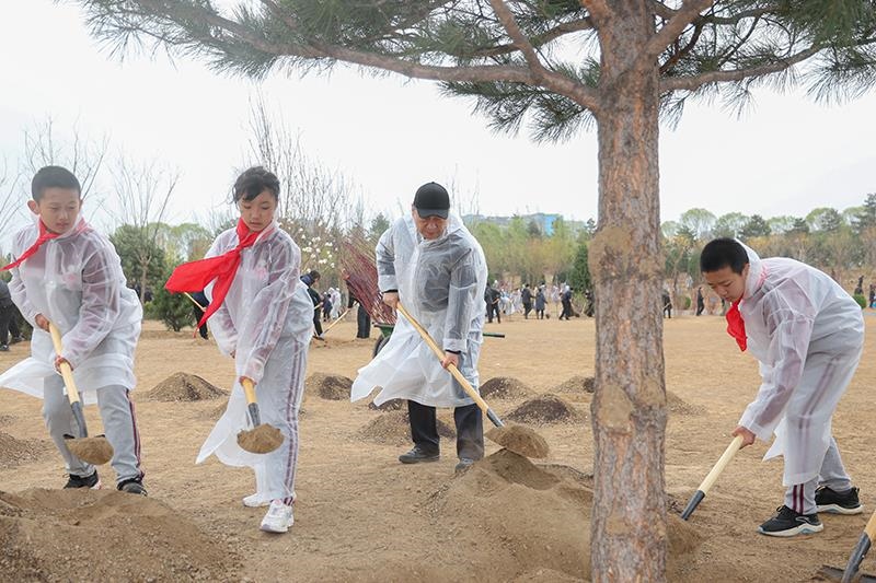 2023年4月4日，习近平总书记来到北京市朝阳区东坝中心公园参加首都义务植树活动。这是总书记同孩子们一起植树。