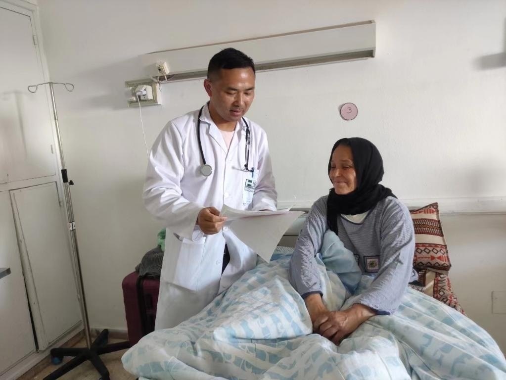 5月1日,中国援突医疗队医护工作者为当地患者玛卜鲁卡检查病情。(医疗队供图)