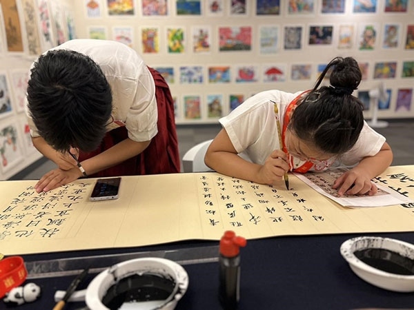参加本次展览的青少年在现场进行书法创作。主办方供图