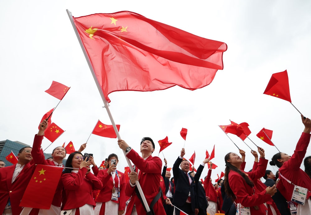 中国体育代表团旗手、乒乓球选手马龙在第33届夏季奥林匹克运动会开幕式前挥舞国旗（2024年7月26日摄）。新华社记者 曹灿 摄