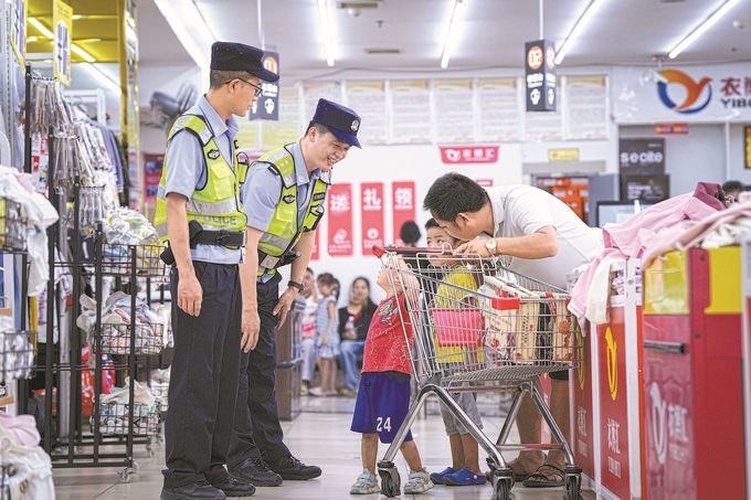 ▶8月27日，贵州省凯里市公安局组织开展拉网式大排查，民警在超市和群众交流。周国辉摄