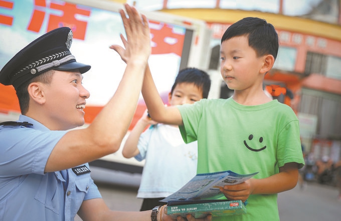 ▲7月10日，江西省吉安市公安局吉州分局组织民警深入辖区开展安全宣传，民警向小朋友讲解防溺水知识。朱文杰摄