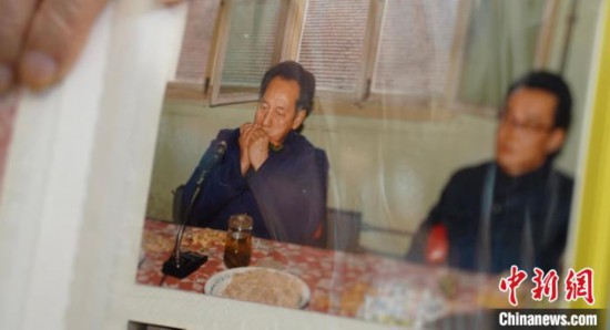 2月7日，刘润林展示1986年黄旭华(左)在同乐会上吹口琴的老照片。中新社记者 邹浩 摄
