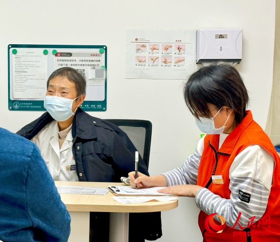 秦苑（中）接诊患者。人民网记者 金慧慧摄