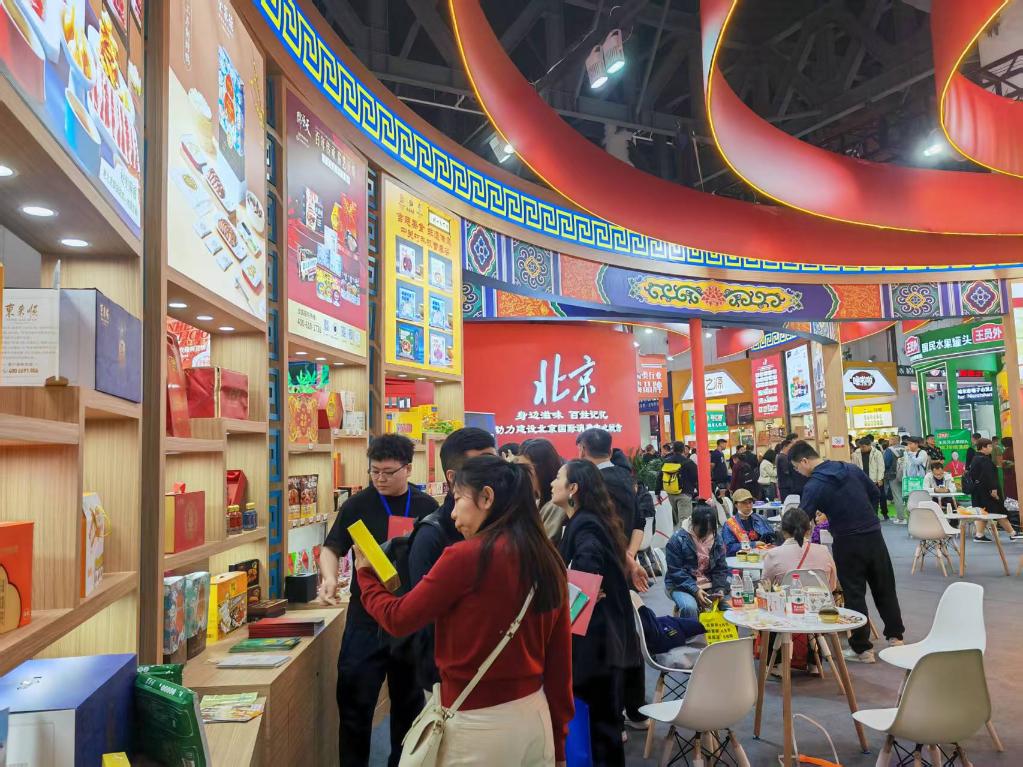 3月25日，在四川省成都市举行的第112届全国糖酒商品交易会中华老字号专区，展商们在展位前交流。新华社记者 张海磊 摄