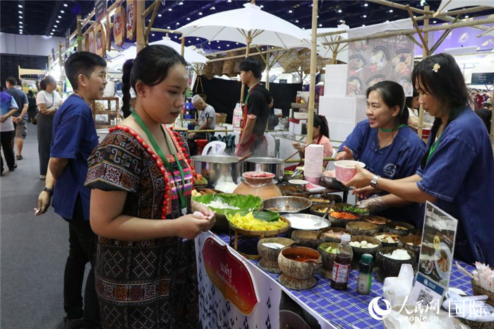 游客在摊位前购买特色美食。朱潇逸摄