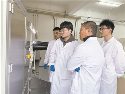 图为安工大材料科学与工程学院硕士研究生余威（右一）在实验室开展研究。安工大供图
