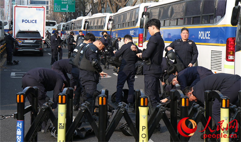 4月4日早，韩国宪法法院前，韩国警察正穿戴防护装备。人民网 李帆摄