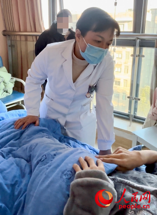 邓茜查房时询问患者情况。人民网记者 金慧慧摄