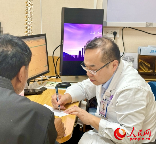 路桂军接诊时为患者写下用药提示。人民网记者 金慧慧摄