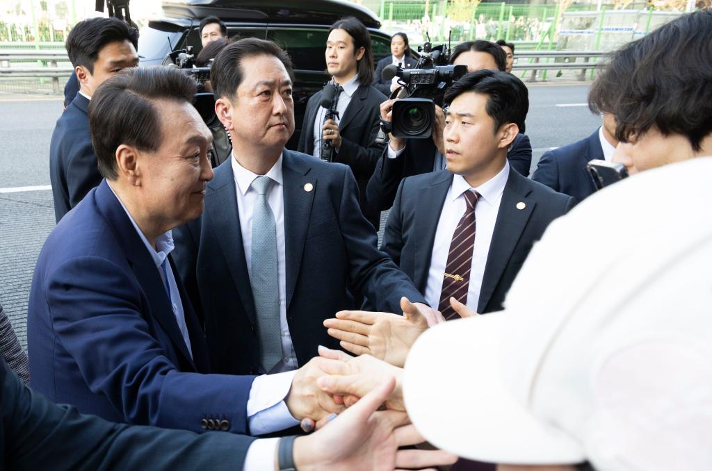 4月11日，韩国前总统尹锡悦（左一）在离开首尔汉南洞官邸时与支持者握手。新华社发（全休相摄）
